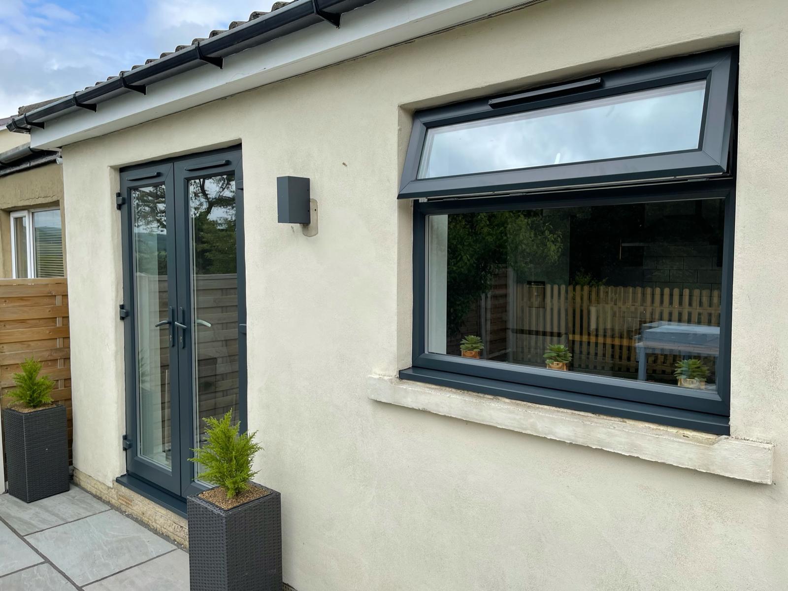 A bungalow with anthracite sprayed window frames and patio doors