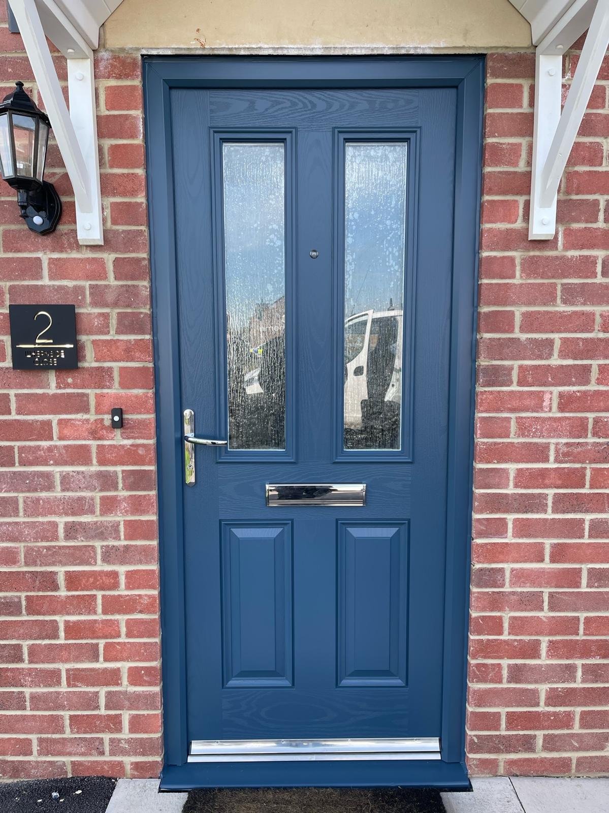 A front door sprayed deep blue against red brick