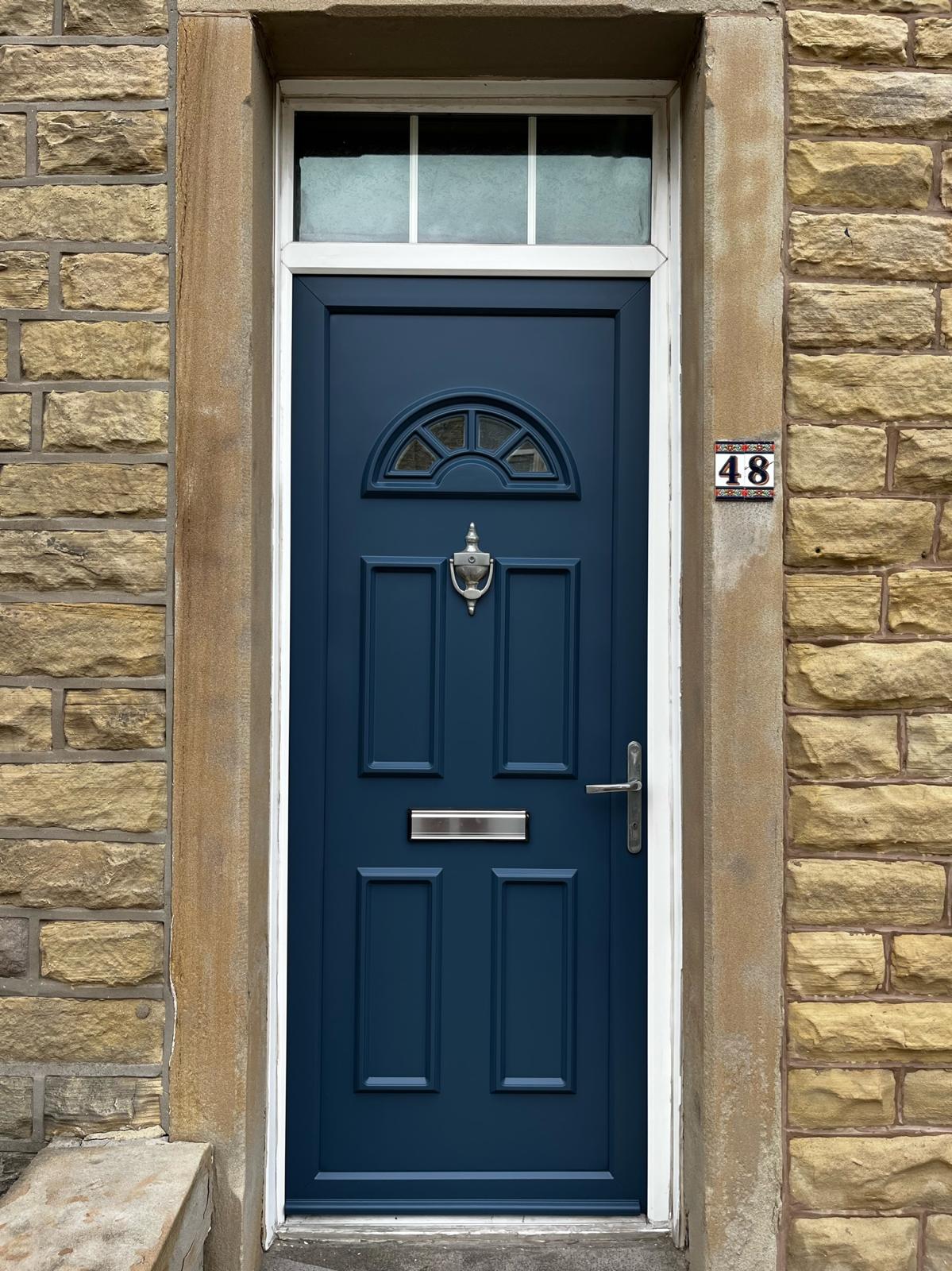 A front door sprayed navy in a stone surround