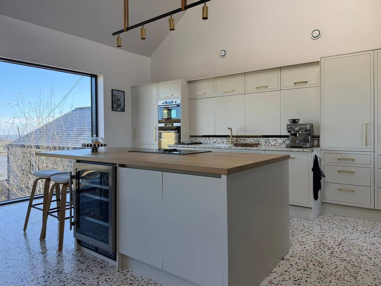 The same kitchen after respraying, with the units and the island in a soft cream