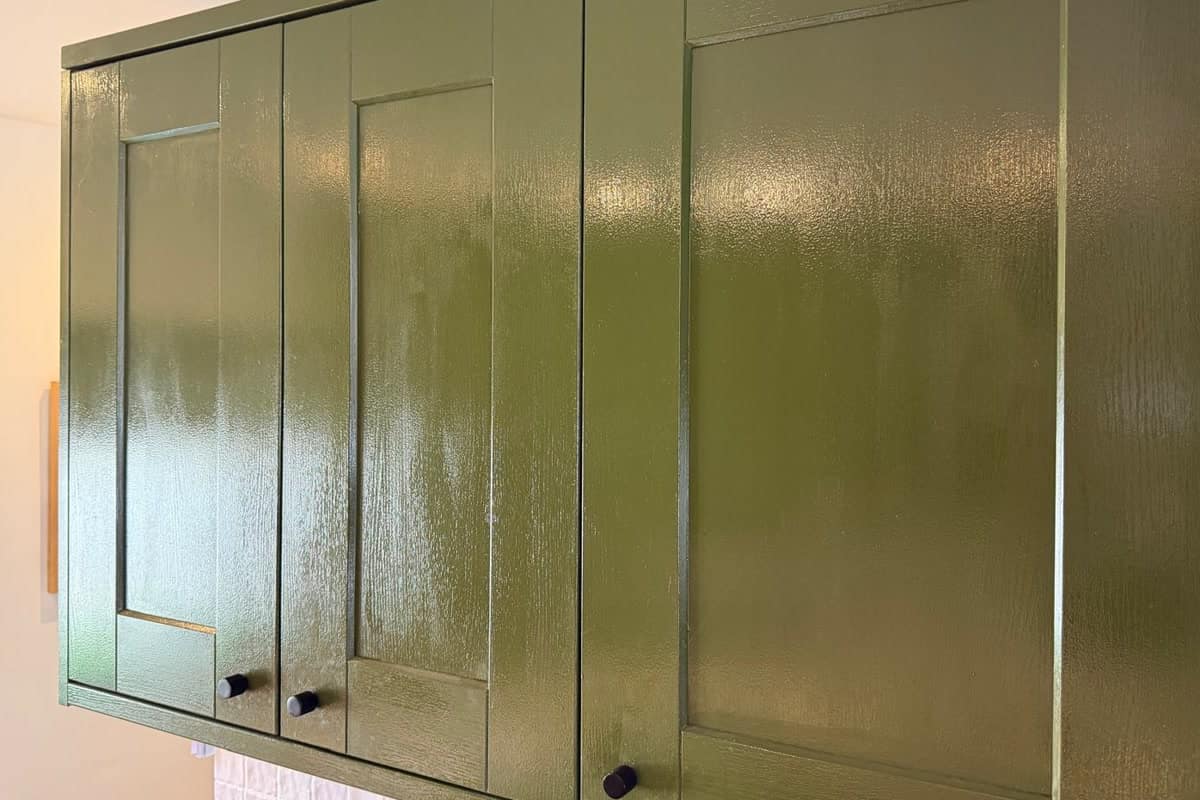 A run of olive green wall cabinets before respraying