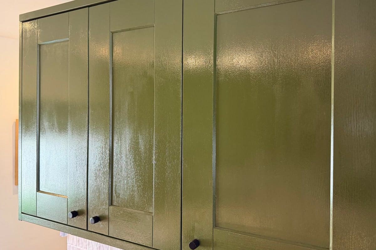 A run of olive green wall cabinets before respraying