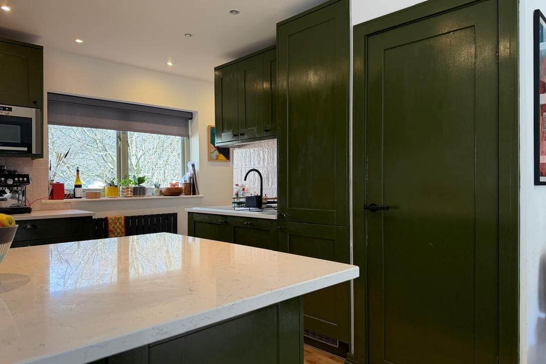 Kitchen before respraying, with olive green units, a white worktop and a tall matching door