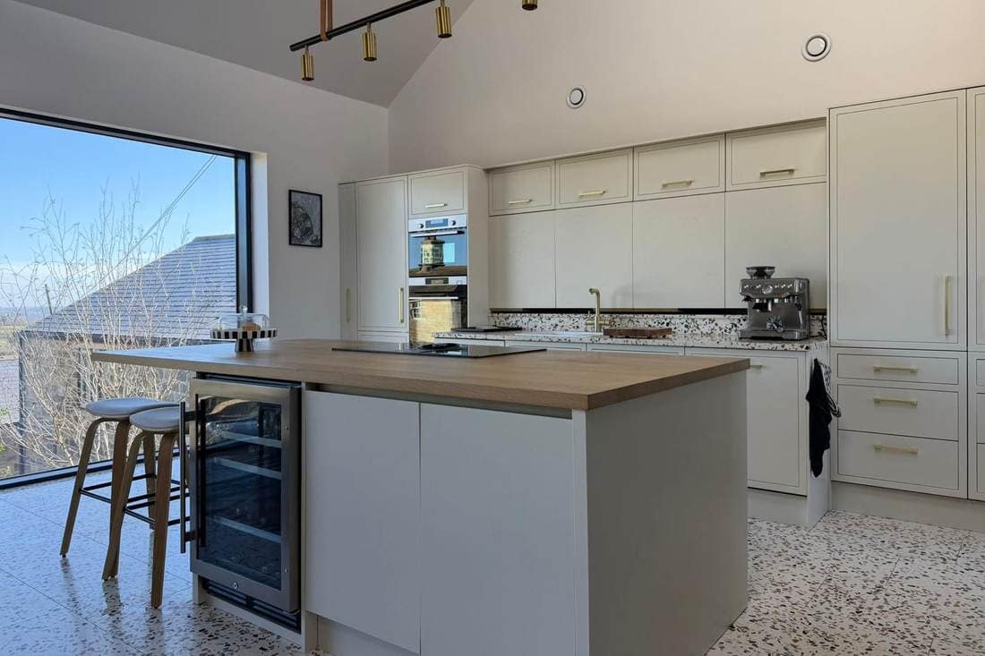 The same kitchen after respraying, with the units and the island in a soft cream