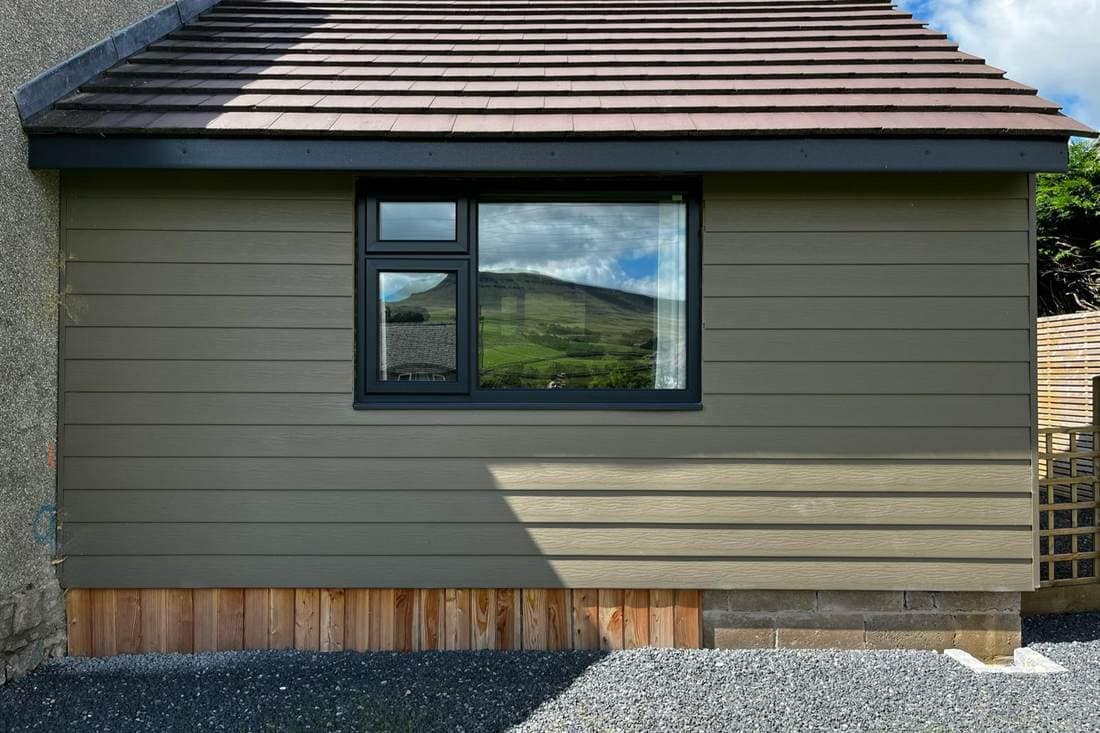 The same garden room after spraying, the cladding in green and the window frame in anthracite