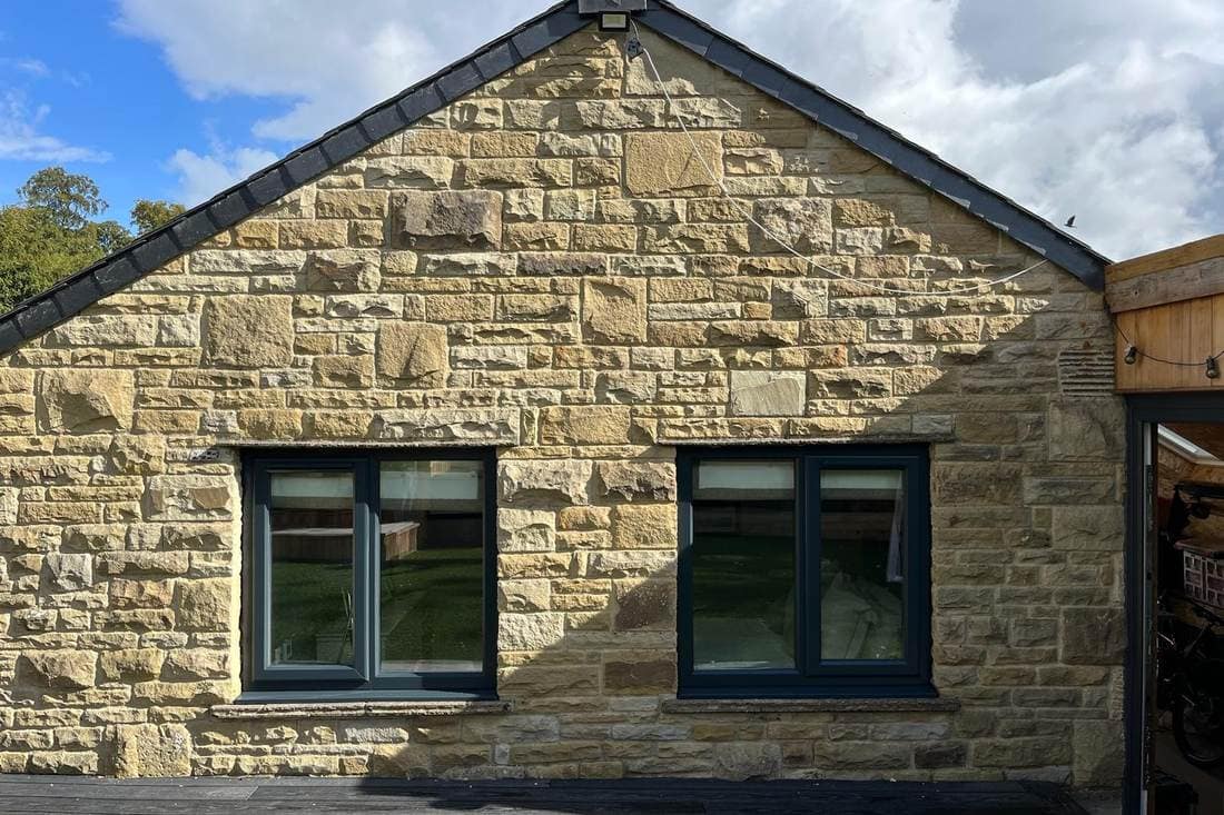 The same gable end after spraying, with both window frames in anthracite