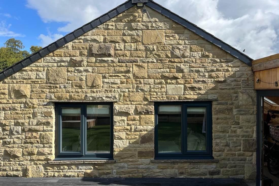 White uPVC windows on a stone gable after spraying in anthracite