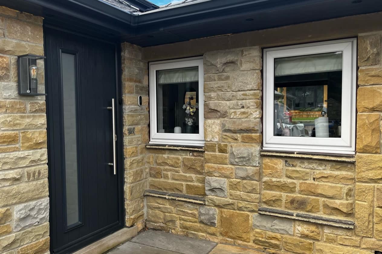 Stone porch before spraying, with white uPVC window frames beside an anthracite entrance door