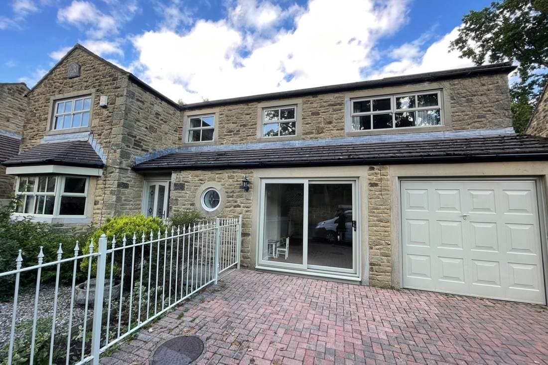 The same house after spraying, with the garage door, window frames, patio doors and railings all in cream and white
