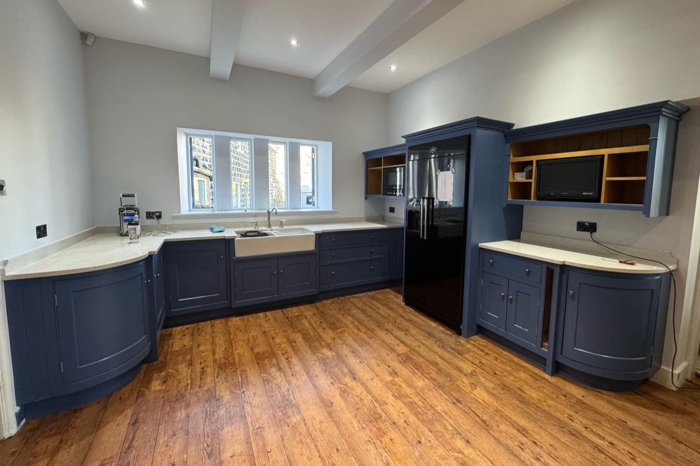 The same kitchen after respraying in a deep navy, with the dresser shelves left in their original oak