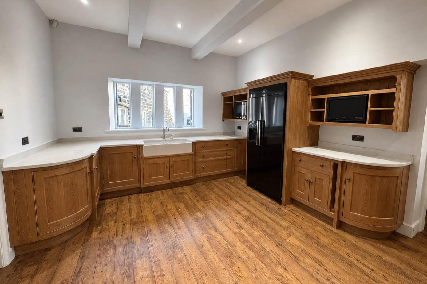 A large in-frame oak kitchen before respraying, with a Belfast sink, a dresser and exposed ceiling beams
