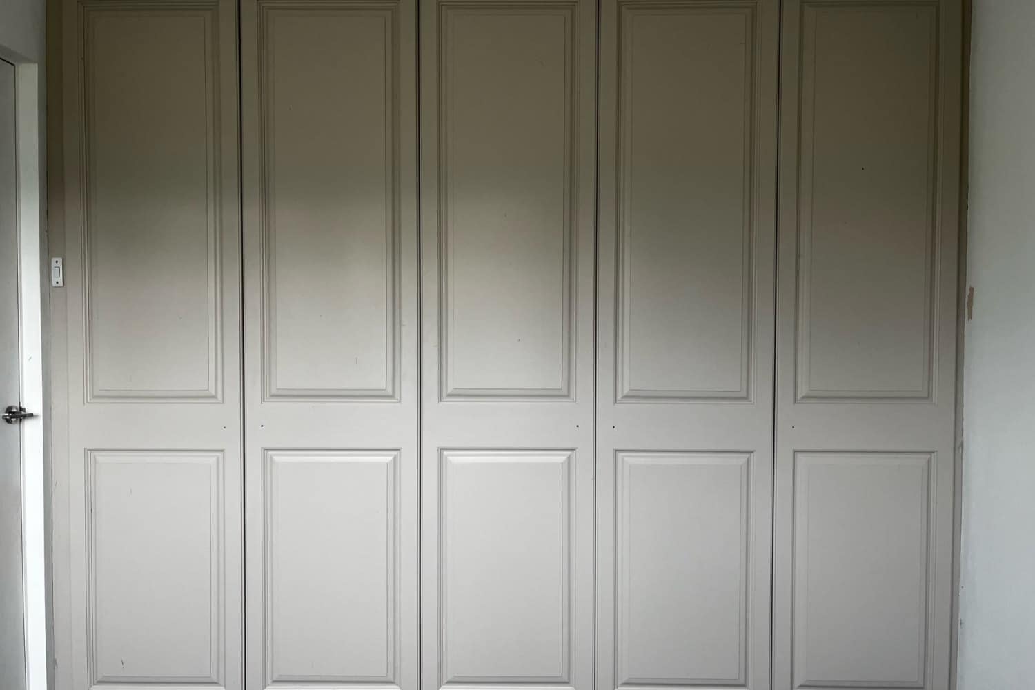 The same wardrobes after spraying in a soft stone, with the surround and architrave matched