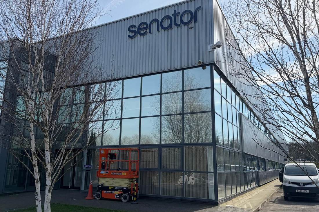 A commercial unit's finished curtain-wall glazing in anthracite, seen from across the car park