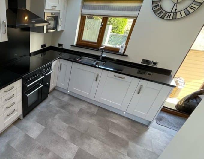The same U-shaped kitchen after respraying, with the oak doors in a soft off-white