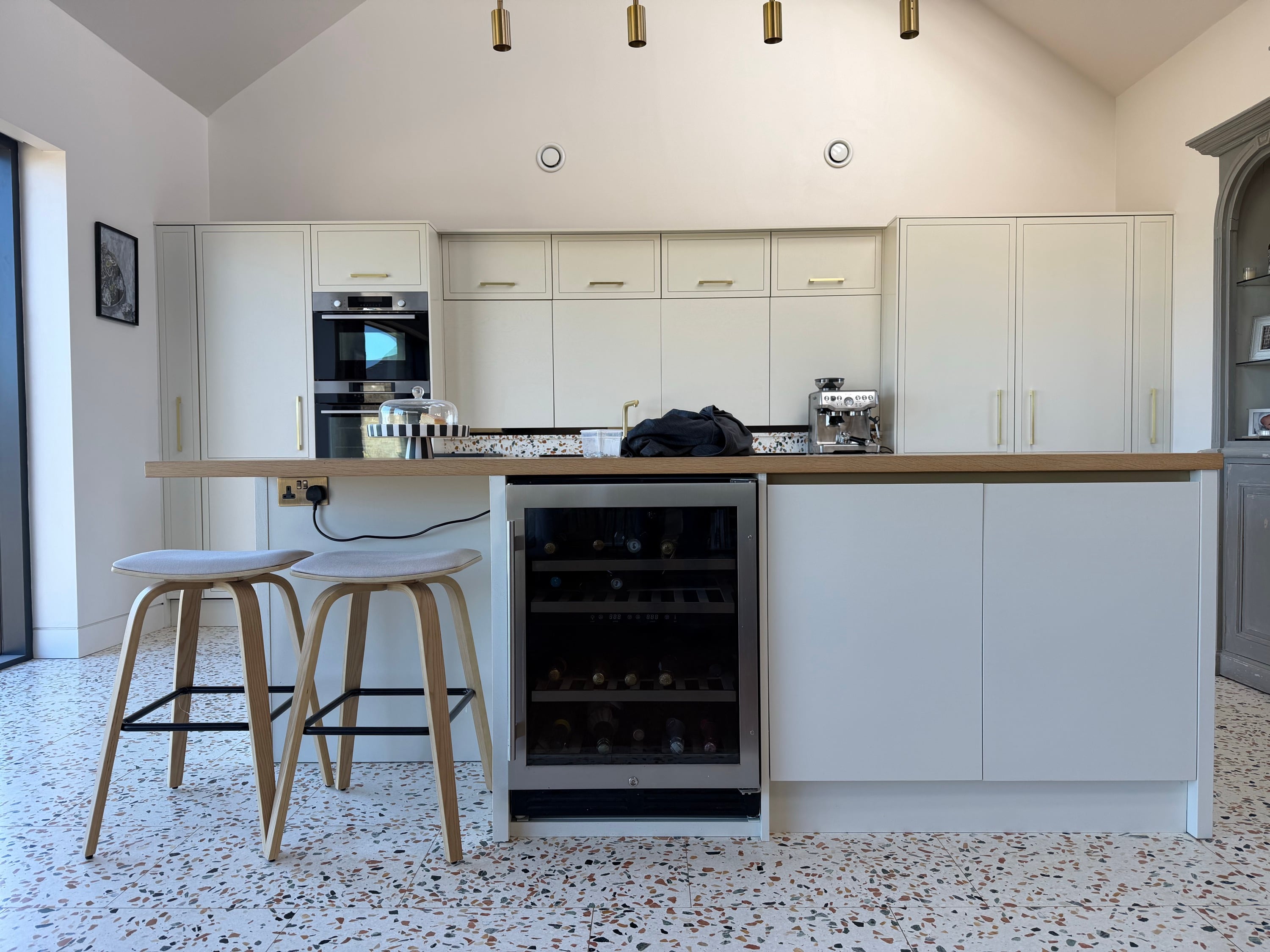 Cream kitchen after respraying, lit by brass pendant lighting