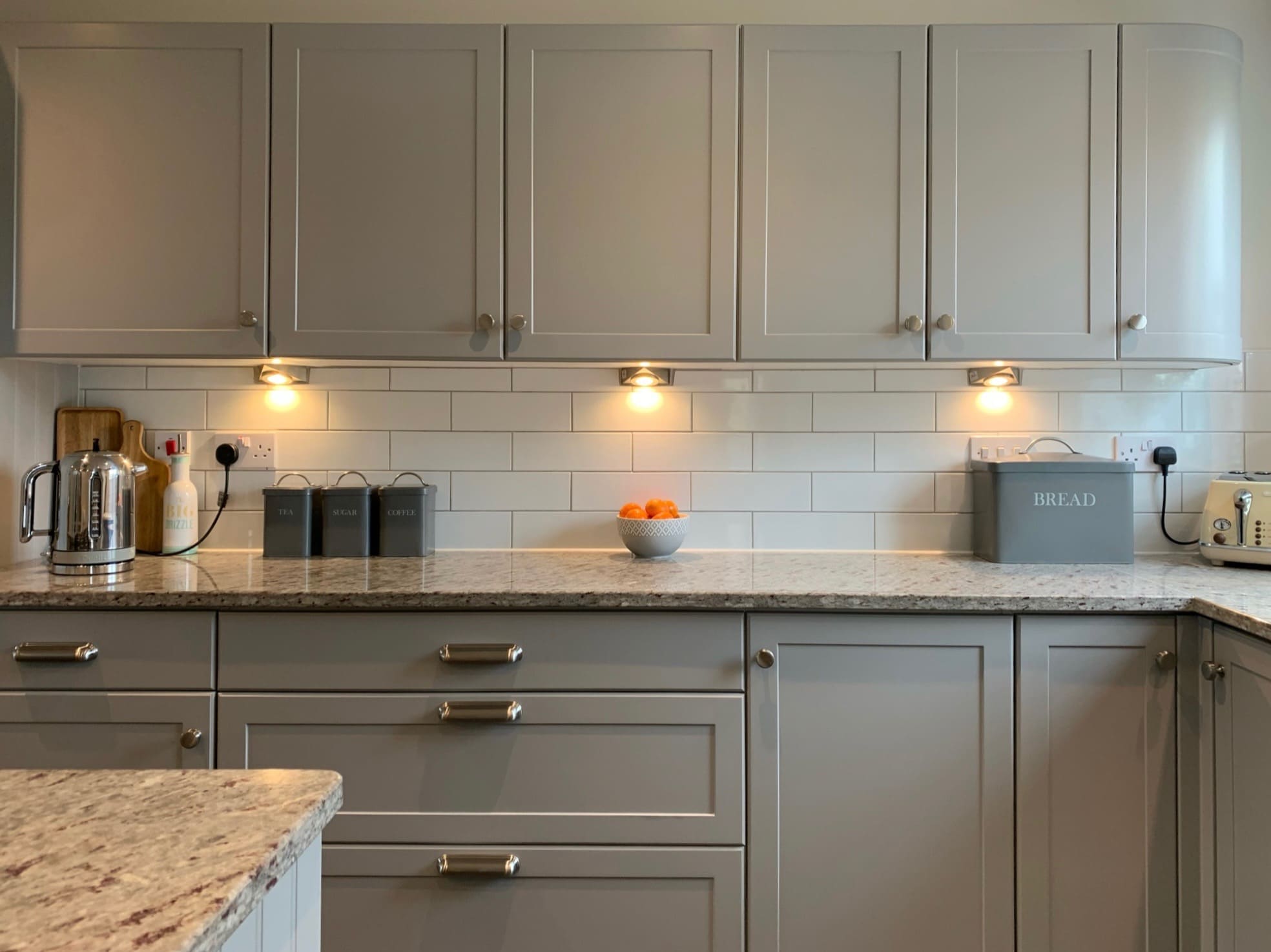 Dove grey kitchen respray with speckled granite worktop and subway tile splashback