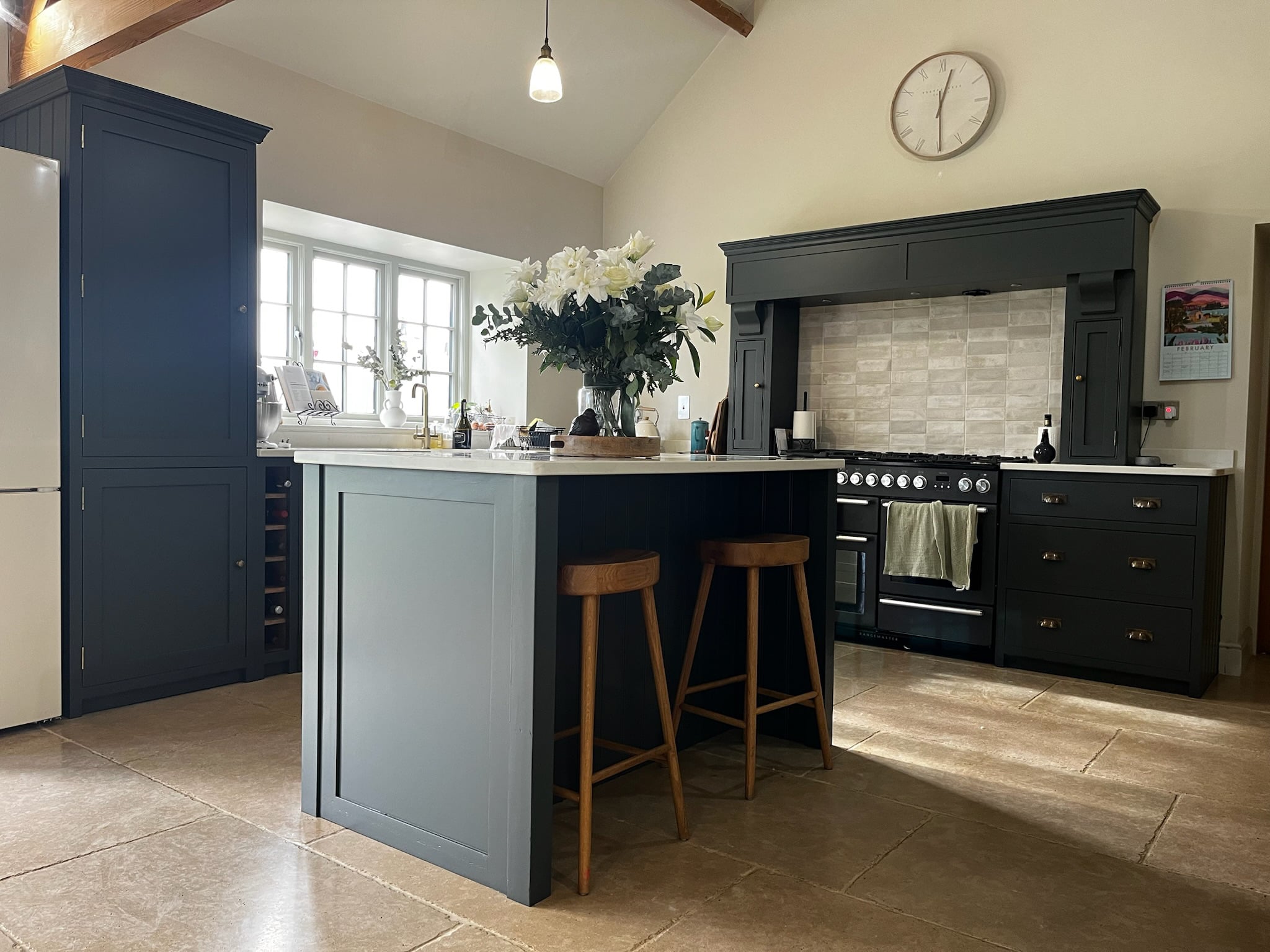 Navy blue kitchen units with brass handles after respraying
