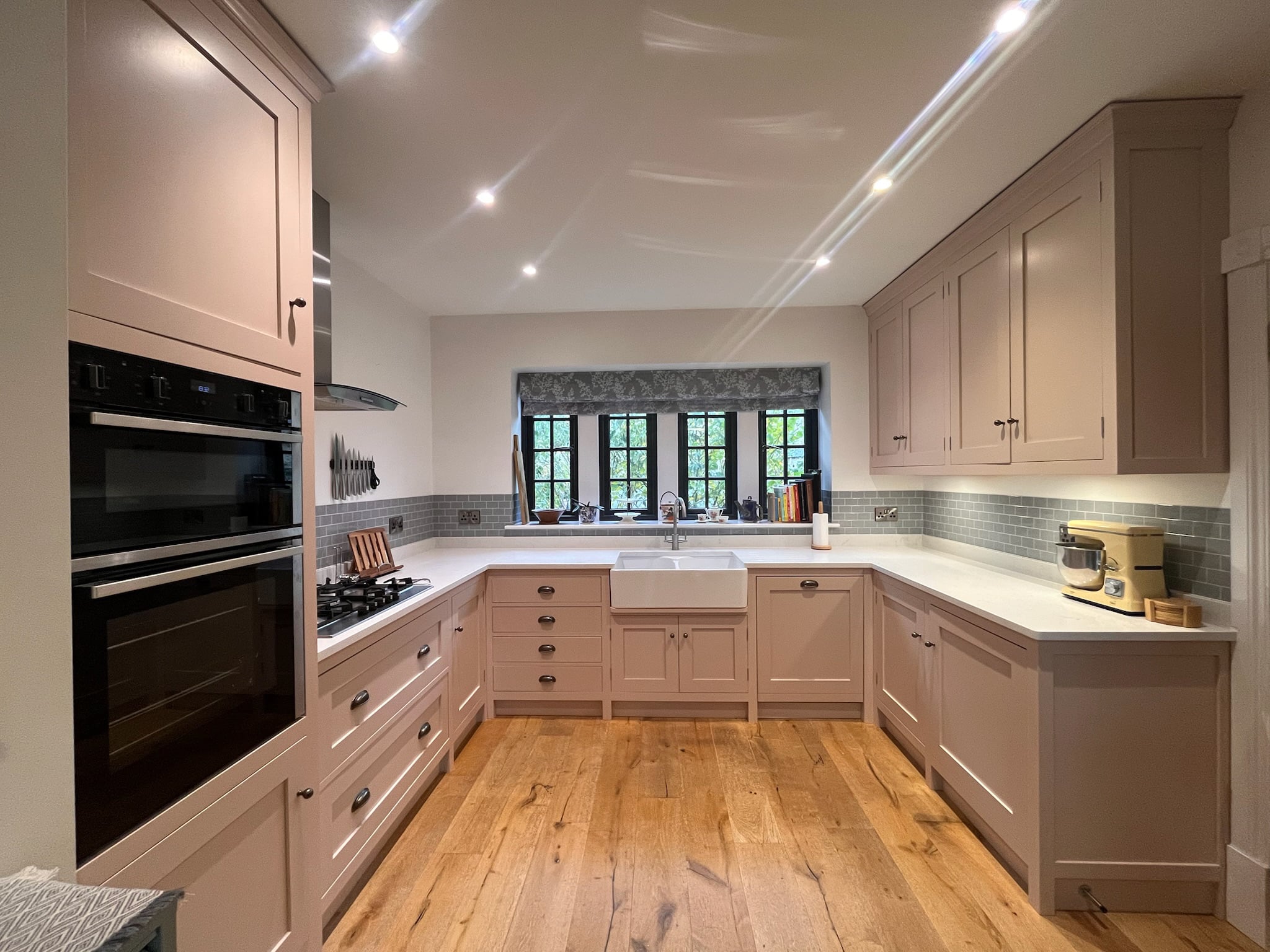 Blush pink kitchen units after respraying, with a marbled worktop