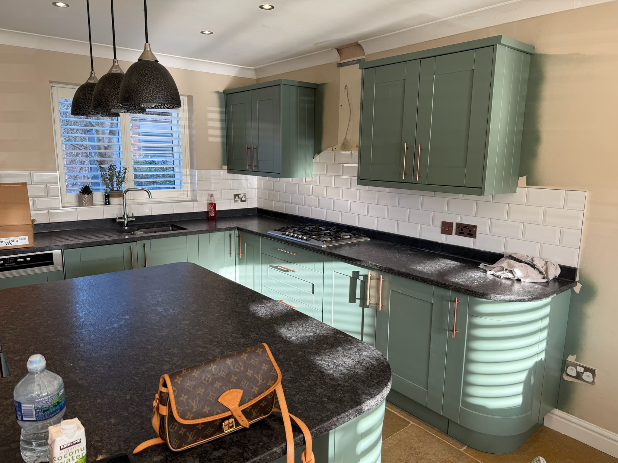 Sage green kitchen respray with a subway tile splashback
