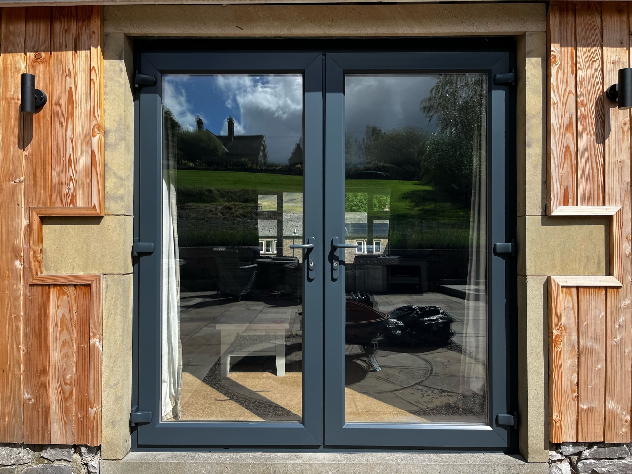 Anthracite sprayed uPVC patio doors set into cedar cladding